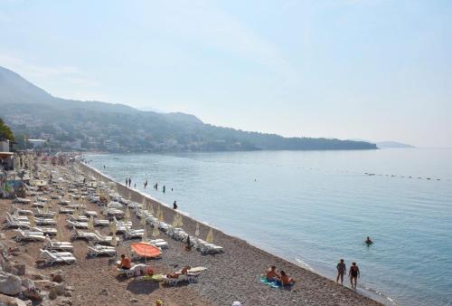 a beach with a bunch of people on it at Apartments Oktopus in Sutomore