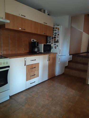 オルショバにあるCasa DucAnaの白い家電製品が備わるキッチン(背景に階段あり)