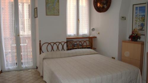 ein Schlafzimmer mit einem Bett in einem Zimmer mit Fenstern in der Unterkunft Bellagio Center Apartment n°12 in Bellagio