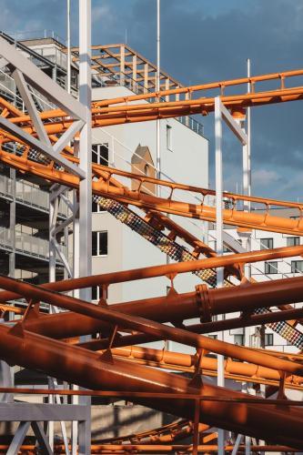 a stack of orange pipes next to a building at Superbude Wien Prater in Vienna