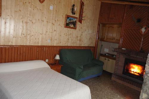 um quarto com uma cama, uma cadeira e uma lareira em CASA RURAL JAVIER " ESTUDIO"e em Las Majadas