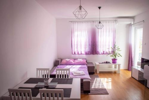 Una habitación con dos camas y una mesa dentro. en Apartment Helena, en Trebinje