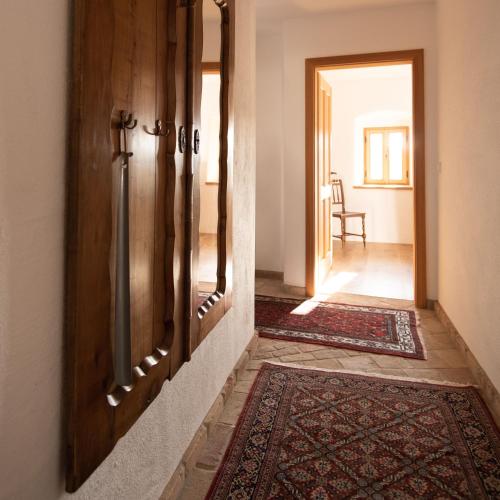 a hallway with a wooden door and a rug at Josefshof in Kühnring