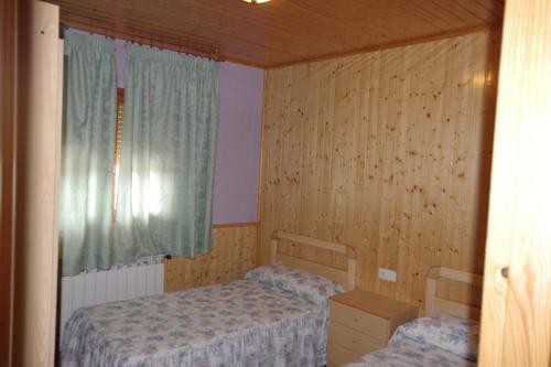 拉斯馬哈達斯的住宿－CASA RURAL JAVIER EL BALCÓN APARTAMENTO 6 PERSONAS，一间小卧室,配有两张床和窗户