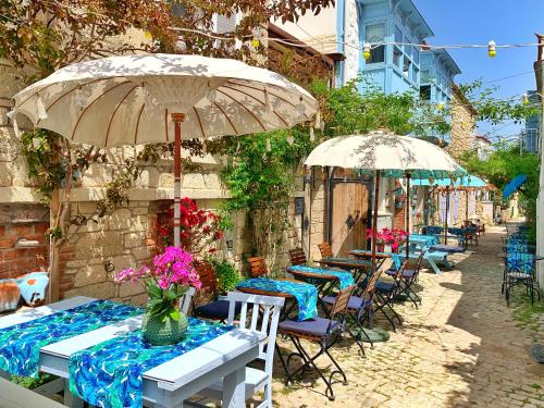 un grupo de mesas y sombrillas en un patio en Rue d'Azur Alaçatı, en Alacati