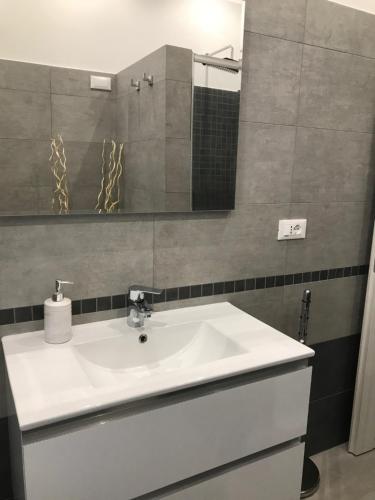 a bathroom with a white sink and a mirror at Appartamento la Perla - vicino al mare in Anzio
