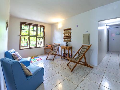 a living room with two chairs and a blue couch at Pousada Charle Brown in Garopaba