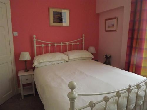 クロマーティにあるSydney Houseの赤い壁の白いベッドが備わるベッドルーム1室