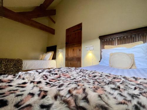 1 dormitorio con 1 cama grande con manta de estampado animal en Cosy 2 bedroom apartment, terrace with Hot Tub 8am - 10pm plus private daily use of indoor pool and sauna 1 hour, en Stanton in Peak