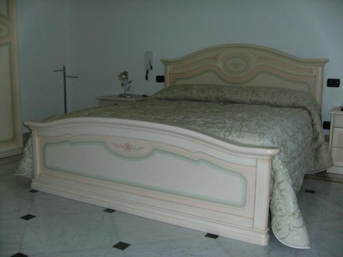 a large bed in a bedroom with a cross on the wall at Villa Gloria Bed & Breakfast in Veglie