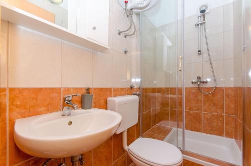 a bathroom with a sink and a toilet and a shower at Apartments Seaview in Tučepi