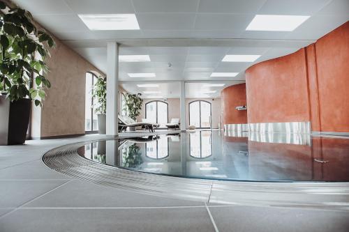 un vestíbulo con piscina en medio de una habitación en Hotel Freihof en Prichsenstadt