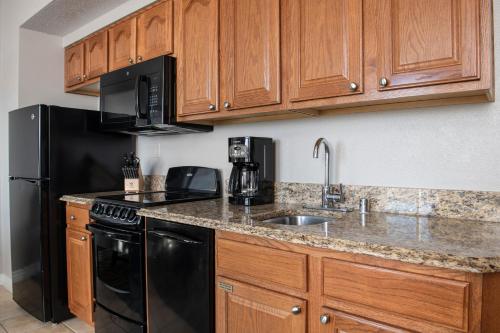 a kitchen with a black refrigerator and a sink at Club Wyndham Grand Desert in Las Vegas
