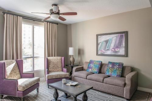 a living room with a couch and two chairs at Club Wyndham Grand Desert in Las Vegas
