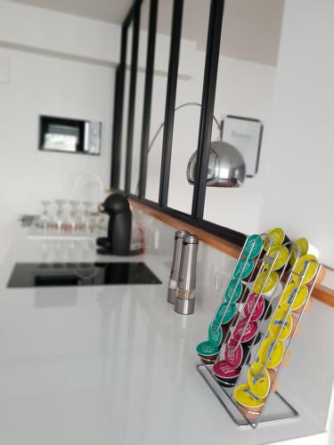 um balcão de cozinha com uma fila de copos coloridos em Suite room jacuzzi sauna privatif illimité Clisson em Clisson