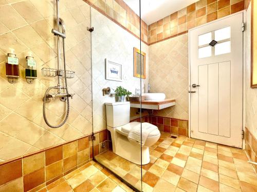 a bathroom with a shower and a toilet and a sink at SpoonDrift Hostal Kenting in Nanwan