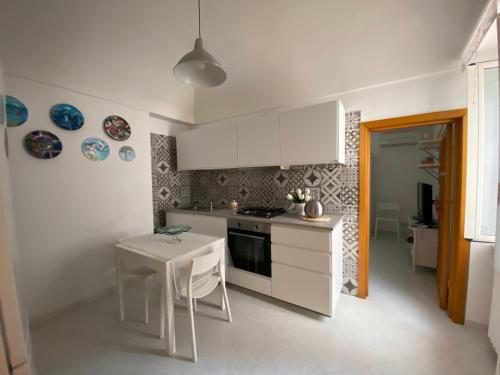 a kitchen with white cabinets and a table and a stove at La casa di Nonna Clo, nel centro di Vasto in Vasto