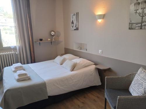 a bedroom with a bed with two towels on it at Hôtel Ambroise in Uzerche