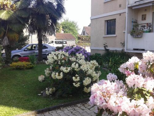 un giardino con fiori rosa e bianchi in un cortile di Les Floralies bis a Pau