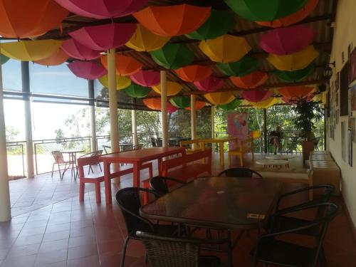 Zimmer mit Tisch, Stühlen und Sonnenschirmen in der Unterkunft Villa Paulina in Guadalupe