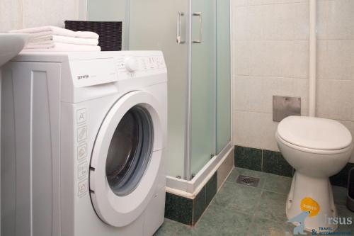 a white washing machine in a bathroom with a toilet at Apartment Janjiš in Split