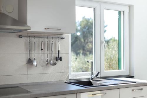 uma cozinha com um lavatório, uma janela e utensílios em Olive Eden Holiday Home em Milna