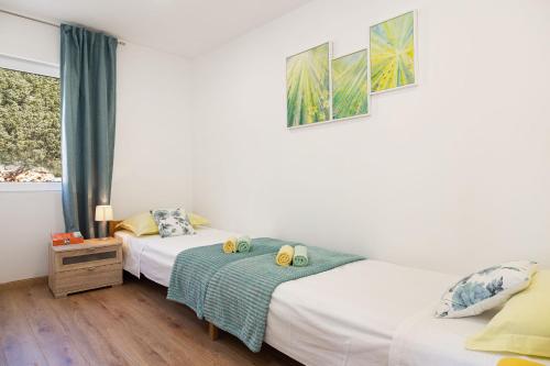 een slaapkamer met twee bedden en een raam bij Olive Eden Holiday Home in Milna