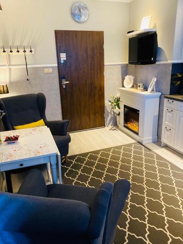 a living room with a couch and a table and a fireplace at Apartamenty Blisko Centrum in Toruń