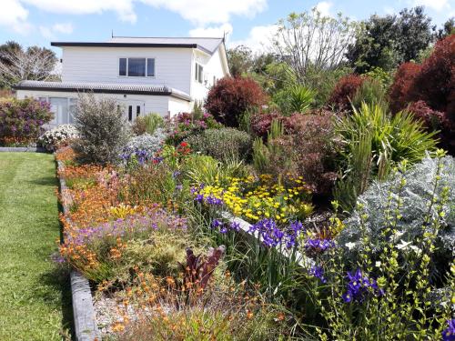 a garden in front of a house with flowers at Hyecroft Lodge in Whangarei