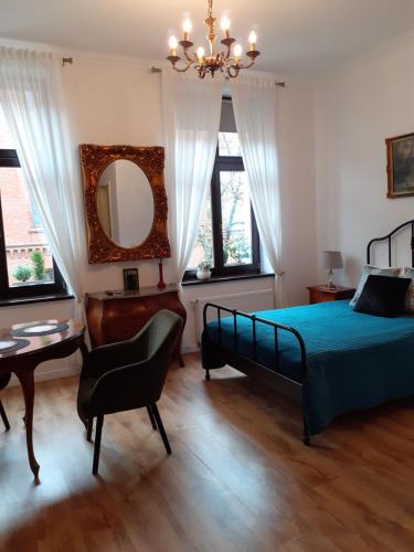 een slaapkamer met een bed, een bureau en een spiegel bij Apartment lux gimnazjalna in Bydgoszcz