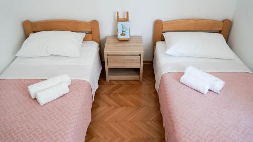 2 Einzelbetten in einem Zimmer mit einem Nachttisch in der Unterkunft Nora Wine House in Split