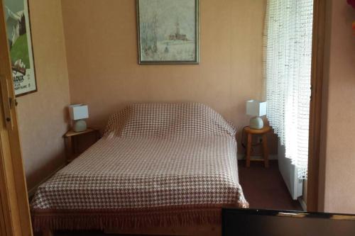 a bedroom with a bed and two lamps on two tables at Appart en rez de jardin clos face au Mont BLANC in Combloux