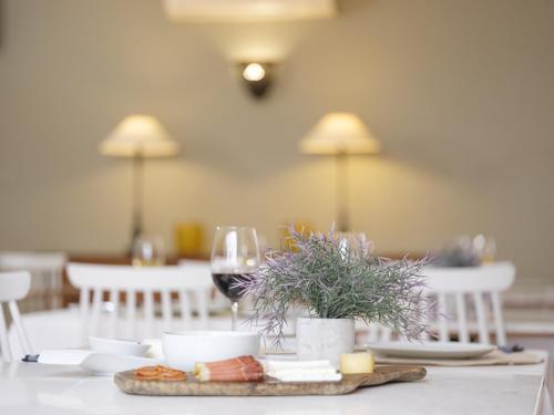 a table with a plate of food and a glass of wine at ADC - Albergaria Do Calvário - by Unlock Hotels in Évora
