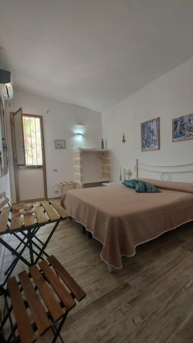 a bedroom with a large bed and a table and chairs at Il corallo rosso in Favignana