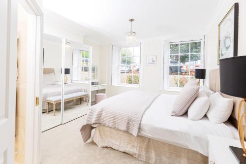 1 dormitorio blanco con 1 cama grande y ventanas en 16 Lansdown -By Luxury Apartments, en Cheltenham