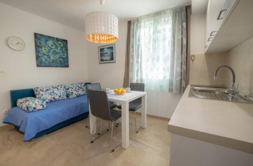 a kitchen and a living room with a table and a couch at Apartments Bogica in Makarska