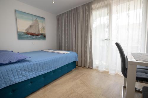 a bedroom with a bed and a window with a sailboat at Apartments Bogica in Makarska