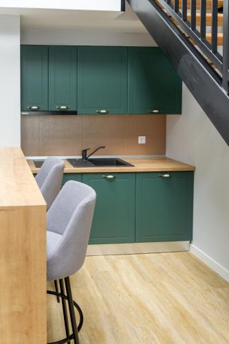 a kitchen with green cabinets and a sink at H11 Downtown Apartments in Târgu-Mureş