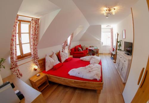 a bedroom with a red bed in a attic at Gästehaus Schmelz in Weissenkirchen in der Wachau