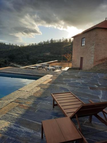 a patio with a picnic table and a building at Quinta da Caída in Arcas