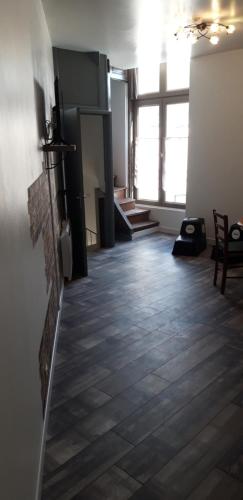 a room with a fireplace and a wooden floor at À 18min du ZOO 30min des 24h du Mans in Le Lude