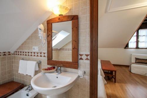 y baño con lavabo y espejo. en Hotel Rural El Espino, en Cangas de Onís