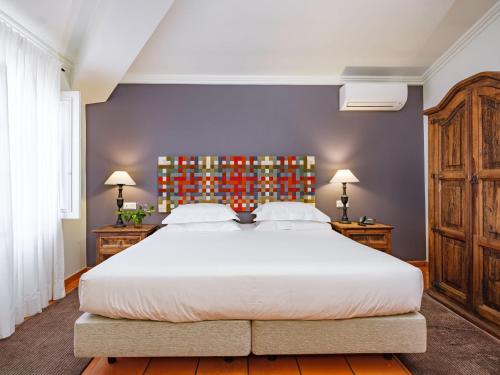a bedroom with a large white bed and two dressers at ADC - Albergaria Do Calvário - by Unlock Hotels in Évora