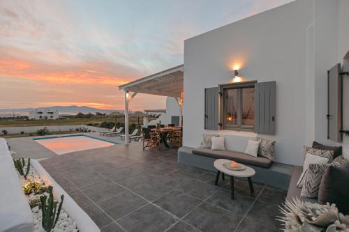 a patio of a house with a couch and a table at Villa Tranquillity in Kastraki Naxou