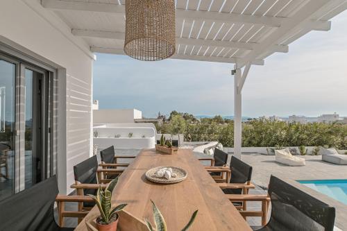 a wooden table and chairs on a patio with a view at Villa Tranquillity in Kastraki Naxou