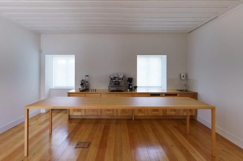 un grande tavolo in legno in una stanza con due finestre di Quinta da Caída ad Arcas