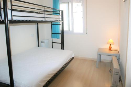 a bedroom with two bunk beds and a table at Apartamento con vistas al canal en residencia con piscina in Roses