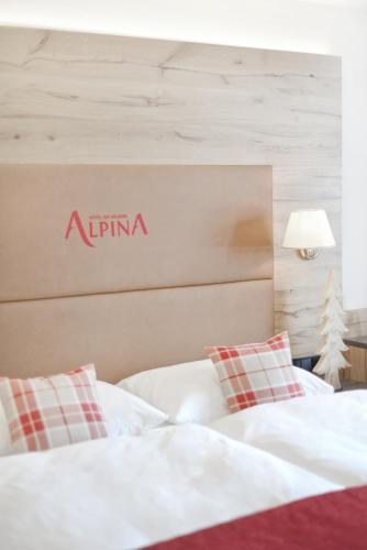 a bedroom with two beds with aania sign on the wall at Hotel Alpina Superior in Pettneu am Arlberg