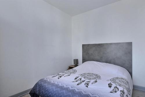 a bedroom with a white bed with a gray headboard at Appartement 2 pièces plein de charmes - Caroline in Valentigney