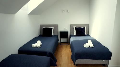 two beds with white shoes on them in a room at Apartament Osiedle Zielone in Chmielno